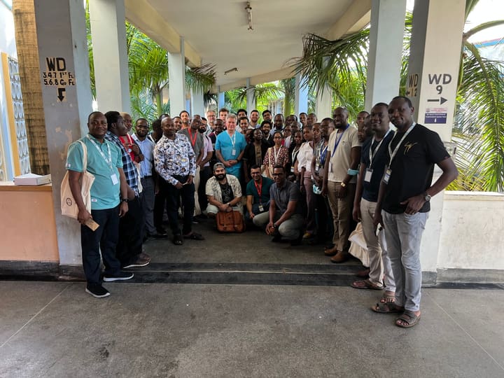 A large group of colleagues gathered outside a meeting room
