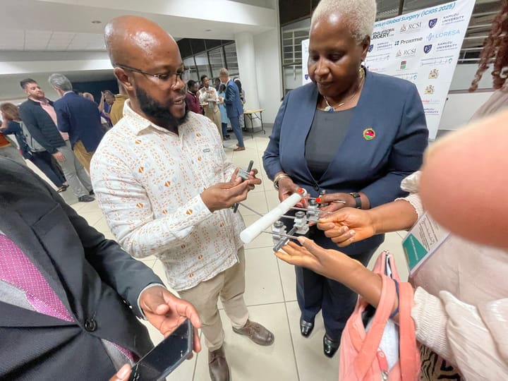 Delegates discussing a handheld device at the congress